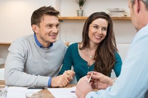 Smiling couple working with accountant on financial documents